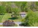 Charming home with a two-car garage, a well-maintained lawn, and a surrounding landscape of lush trees at 174 Stewart Acres Dr, Statesville, NC 28677