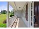 Inviting covered front porch with classic white railings and a serene, shaded ambiance at 260 Treebark Rd, Statesville, NC 28625
