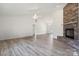 Bright living room featuring a stone fireplace, ceiling fan, and wood-look flooring at 260 Treebark Rd, Statesville, NC 28625