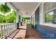 Inviting front porch featuring wood flooring, white columns and railing, and leafy green ferns at 309 N Congress N St, York, SC 29745