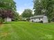 Expansive backyard with lush green lawn, mature trees, and detached garage at 3615 Champaign St, Charlotte, NC 28210