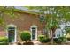 Brick townhouse with green front door, white trim and manicured bushes at 3736 Melrose Cottage Dr, Matthews, NC 28105