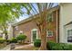 Brick townhouse featuring a welcoming entryway, mature trees, and well-maintained landscaping at 3736 Melrose Cottage Dr, Matthews, NC 28105