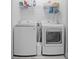 Functional laundry room with washer, dryer, and built-in shelving for storage at 3736 Melrose Cottage Dr, Matthews, NC 28105