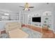 Bright living room features hardwood floors, custom built-ins, and a ceiling fan at 3736 Melrose Cottage Dr, Matthews, NC 28105