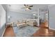 Cozy living room with hardwood floors, comfortable sofas and a ceiling fan at 3736 Melrose Cottage Dr, Matthews, NC 28105