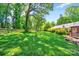 Expansive backyard with lush green grass, mature trees, and a charming wooden fence at 3810 Springway Dr, Gastonia, NC 28056