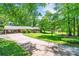 Brick ranch home featuring a spacious driveway, mature landscaping and a covered carport at 3810 Springway Dr, Gastonia, NC 28056