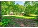 Charming home with well-manicured front yard featuring lush greenery, mature trees, and a covered porch at 3810 Springway Dr, Gastonia, NC 28056
