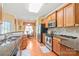 Well-lit kitchen with wood cabinets, stainless steel appliances, granite countertops, and eat-in dining area at 44449 Oriole Dr # 101, Indian Land, SC 29707