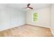 Bright bedroom featuring hardwood floors, modern accent wall and large window view at 4907 Ardenwoods Dr, Charlotte, NC 28215