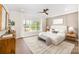 Bright bedroom featuring large windows, neutral walls and sophisticated decor, with a stylish ceiling fan at 4907 Ardenwoods Dr, Charlotte, NC 28215