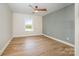 Bright bedroom with a modern ceiling fan, hardwood floors, and a stylish accent wall at 4907 Ardenwoods Dr, Charlotte, NC 28215