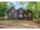 Stately brick home featuring a well-manicured lawn, mature trees and traditional architectural details at 4907 Ardenwoods Dr, Charlotte, NC 28215