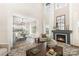 Cozy living room adjacent to the kitchen featuring a fireplace, large windows, and ample natural light at 4907 Ardenwoods Dr, Charlotte, NC 28215
