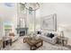 Bright living room featuring high ceilings, large windows, elegant chandelier and a cozy fireplace at 4907 Ardenwoods Dr, Charlotte, NC 28215