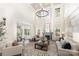 Bright living room with high ceilings, large windows, elegant chandelier and a cozy fireplace at 4907 Ardenwoods Dr, Charlotte, NC 28215