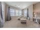 Cozy bedroom area with a patterned armchair, ottoman, and ample natural light from the windows at 5250 Meadowcroft Way, Fort Mill, SC 29708