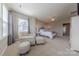 Bright bedroom featuring an upholstered chair and ottoman with ample natural light and neutral decor at 5250 Meadowcroft Way, Fort Mill, SC 29708