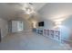 Large bonus room with ceiling fan, plush carpet, TV, shelving, and natural light at 5250 Meadowcroft Way, Fort Mill, SC 29708