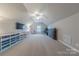 Large bonus room with ceiling fan, plush carpet, TV, shelving, and natural light at 5250 Meadowcroft Way, Fort Mill, SC 29708