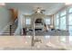 The kitchen island features a stainless steel faucet and a view into the living room with a fireplace at 5250 Meadowcroft Way, Fort Mill, SC 29708