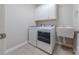 Bright laundry room featuring white cabinetry, modern washer and dryer, and utility sink at 5250 Meadowcroft Way, Fort Mill, SC 29708
