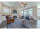 Bright living room featuring large windows, a fireplace, ceiling fan, and comfortable seating at 5250 Meadowcroft Way, Fort Mill, SC 29708