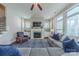 Cozy living room with a fireplace, large windows, comfortable sofa, and a patterned rug at 5250 Meadowcroft Way, Fort Mill, SC 29708