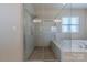 Contemporary walk-in shower with rainfall showerhead and bench and adjacent soaking tub at 5250 Meadowcroft Way, Fort Mill, SC 29708