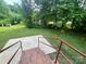 Expansive backyard featuring lush greenery and a well-maintained lawn, accessible from a brick staircase at 601 Scottsbrook Dr, Charlotte, NC 28213
