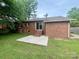 Brick home exterior with a concrete patio and stairs leading to a sliding glass door at 601 Scottsbrook Dr, Charlotte, NC 28213