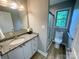 Updated bathroom with granite countertop, framed mirror, and glass shower door at 601 Scottsbrook Dr, Charlotte, NC 28213