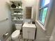 Charming half bathroom featuring floating shelves, and a modern sink at 601 Scottsbrook Dr, Charlotte, NC 28213