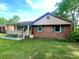Charming single-story brick home featuring a cozy front porch and well-maintained lawn at 601 Scottsbrook Dr, Charlotte, NC 28213