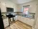 Updated kitchen featuring stainless steel appliances, white cabinets, granite countertops, and vinyl flooring at 601 Scottsbrook Dr, Charlotte, NC 28213