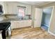 Kitchen with white cabinets, stainless steel appliances, granite counters and updated vinyl flooring at 601 Scottsbrook Dr, Charlotte, NC 28213