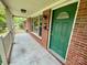 Inviting front porch with white railing, brick accents, and green front door at 601 Scottsbrook Dr, Charlotte, NC 28213
