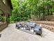 Inviting back patio with stylish outdoor furniture, perfect for relaxation and entertaining in a serene, wooded setting at 6017 Lake Providence Ln, Charlotte, NC 28277