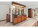 Cozy bar area featuring wood cabinetry, shelving, and a convenient sink at 6017 Lake Providence Ln, Charlotte, NC 28277