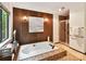 Bathroom features a relaxing soaking tub, shower, wood paneling, and soft lighting at 6017 Lake Providence Ln, Charlotte, NC 28277