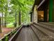 Cozy wooden deck with a seating area, overlooking a serene lake and lush trees, perfect for relaxation at 6017 Lake Providence Ln, Charlotte, NC 28277