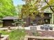 Exterior view of a multi-story home with a beautifully landscaped yard, a patio with dining, and a cozy seating area at 6017 Lake Providence Ln, Charlotte, NC 28277