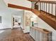Open foyer with a wooden staircase, stylish decor, and brick flooring, leading to various living spaces at 6017 Lake Providence Ln, Charlotte, NC 28277