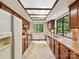 Galley kitchen with wood cabinets, tile countertops, white appliances, and window overlooking yard at 6017 Lake Providence Ln, Charlotte, NC 28277