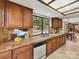 Bright kitchen with tile countertops, white dishwasher, with window offering an outdoor view at 6017 Lake Providence Ln, Charlotte, NC 28277