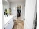 Well-lit bathroom featuring a modern vanity and a view into the walk-in closet, creating a harmonious space at 6114 Paw Village Rd, Charlotte, NC 28214