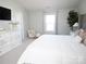 Comfortable bedroom with a white bed, dresser, and a cozy chair by the window offering plenty of natural light at 6114 Paw Village Rd, Charlotte, NC 28214