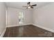 Bright bedroom with ceiling fan and a window offering natural light and outdoor views at 6409 Pineburr Ct, Charlotte, NC 28211