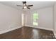 Well-lit bedroom with dark wood-look flooring and a window offering natural light and a peaceful view at 6409 Pineburr Ct, Charlotte, NC 28211